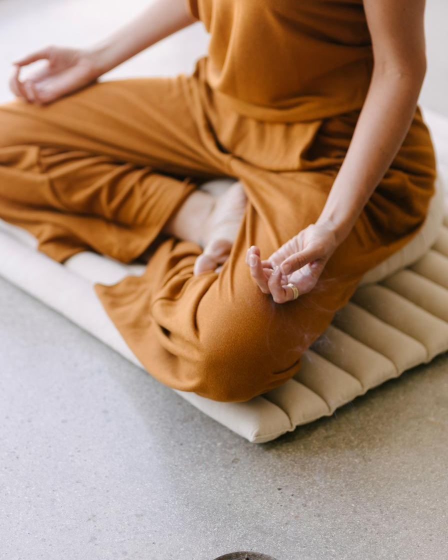 Elle’s hands resting together, incense burning nearby