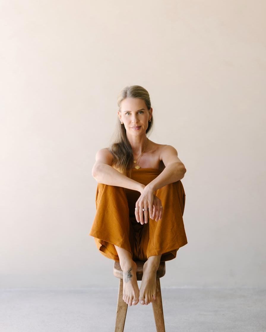 Portrait of Elle Wilk seated on a wooden stool
