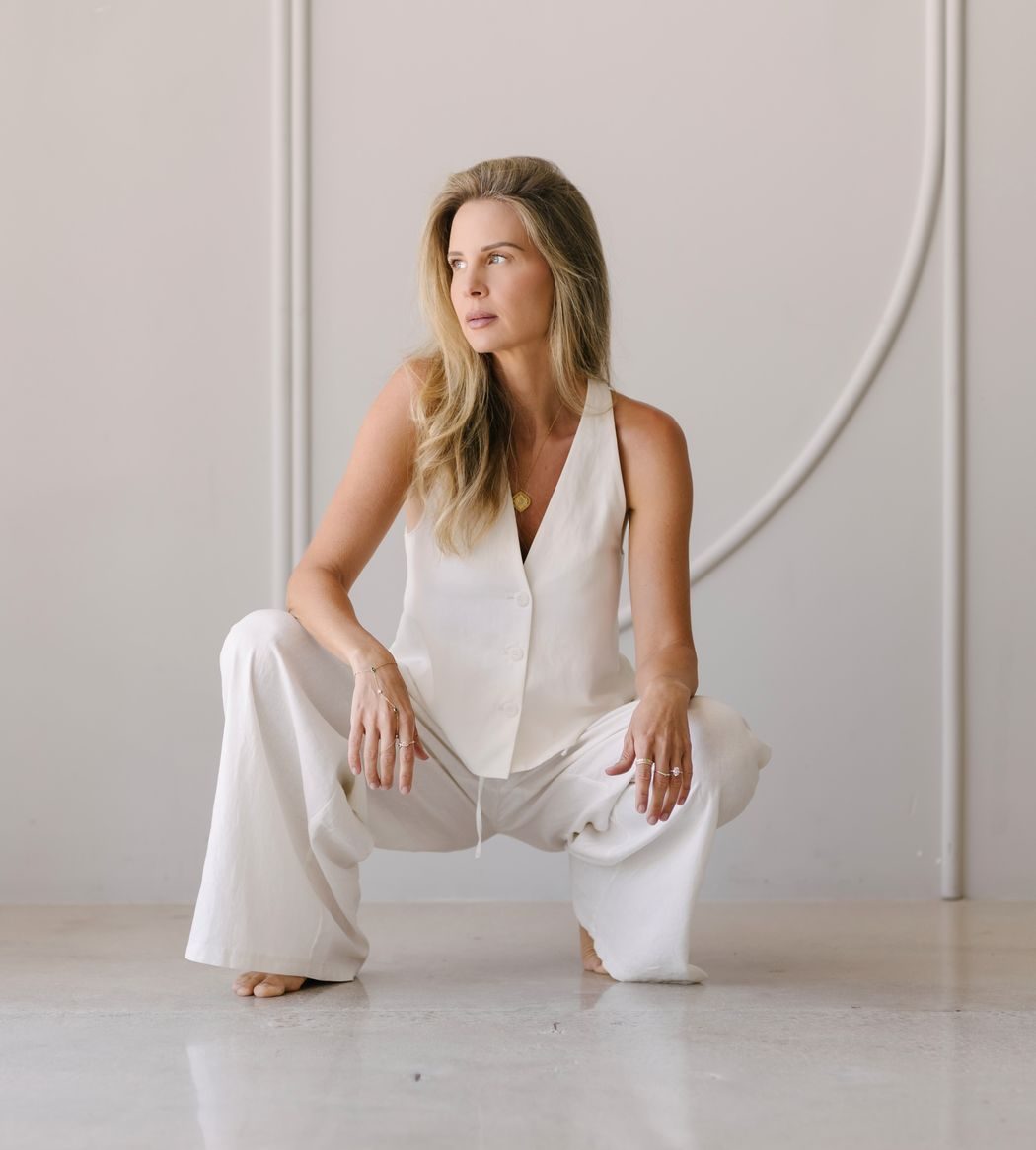 Elle crouched in a bright, architectural room
