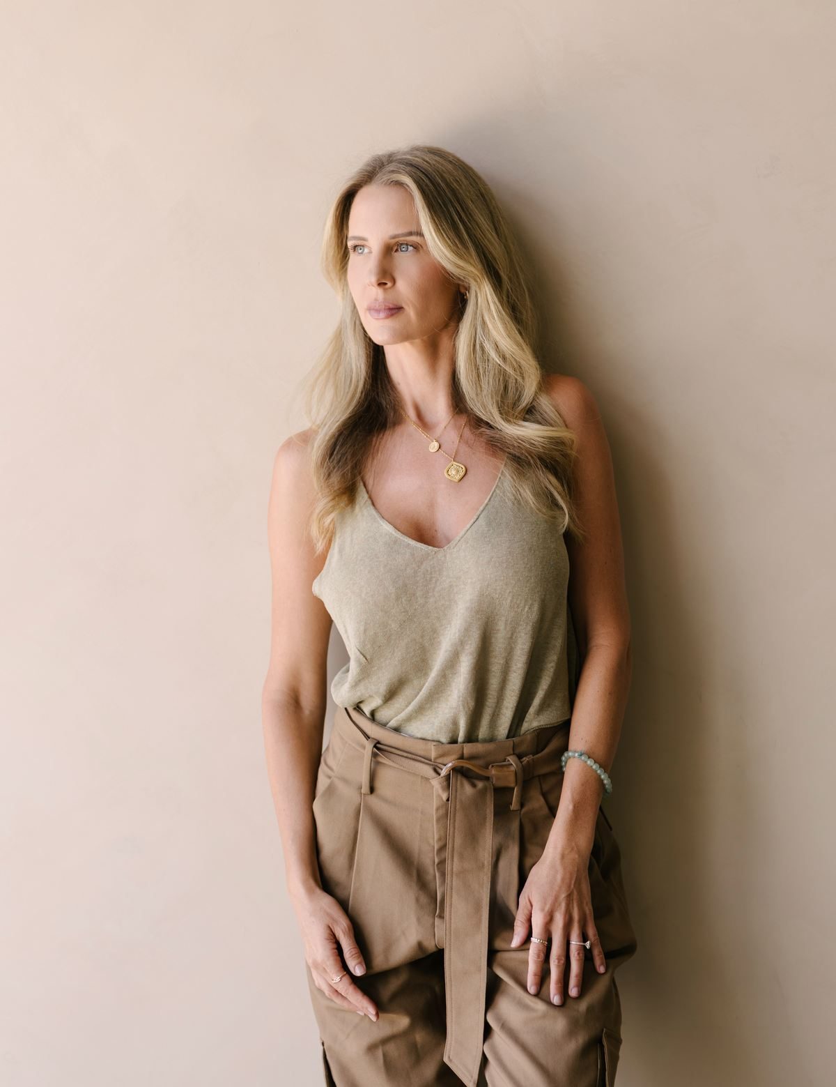 Elle Wilk standing against a warm plaster wall